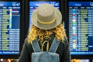 Girl Looking at Airport Flight Schedule